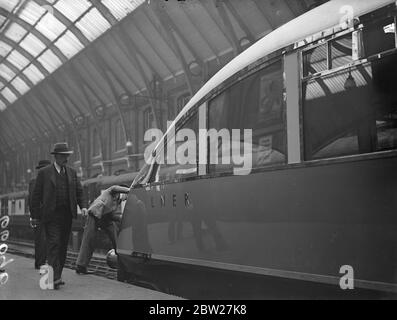 With a schedule under 4 hours for the 210 miles journey, the London and North Eastern Railway's new Coronation streamlined train speeding north to Grantham on a trial run. The locomotive drawing the express is Dominion of Canada, one of the fastest in the British Empire. The train at King's Cross station, attracting the attention of bystanders. 30 June 1937 Stock Photo