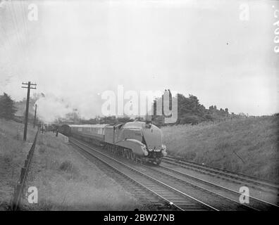 With a schedule under 4 hours for the 210 miles journey, the London and North Eastern Railway's new Coronation streamlined train speeding north to Grantham on a trial run. The locomotive drawing the express is Dominion of Canada, one of the fastest in the British Empire. The train passing through Hadley Wood. 30 June 1937 Stock Photo