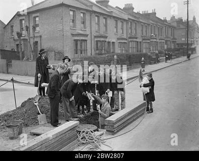 London school children study geography by seeing for themselves. Boys and girls at Dulwich Central School, London, have a new way of learning geography and they are enjoying it. Instead of studying textbooks they are given practical work. Classes are taken for walks to study the geography of their own and other districts, and pupils are allowed to go to the local library to obtain data for maps on population density, industrial works of the area and details of local contours. Factories of importance in the borough are also visited. Photo shows, children of the Dulwich Central School take posse Stock Photo