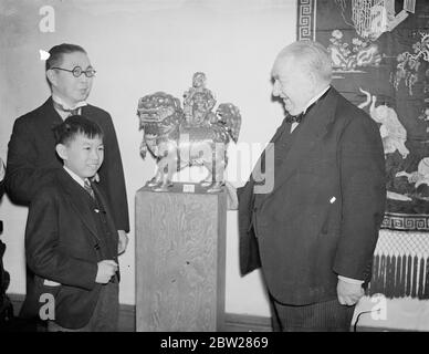 Chinese Ambassador opens Chinese art exhibition in London. 3500 years covered by the Exhibition of Chinese Art opened by Mr Quo Tai Chi, Chinese Ambassador in London at t 9, Conduit Street, in aid of funds for Chinese medical aid. Photo shows, Mr Quo Tai Chi, the Chinese Ambassador, inspecting a piece of K'angai pottery with Sir E Denison Ross and Merlin Quo, son of the Ambassador. 7 January 1938 Stock Photo