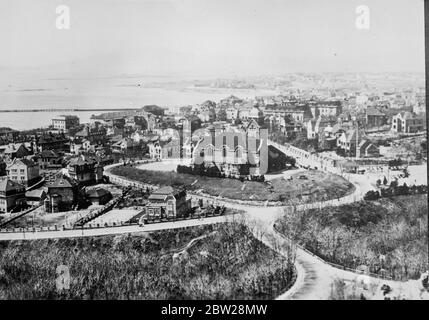 Japan starts big attack on Tsingtao, the northern treaty port in China, while the evacuation of British and American refugees were still being carried out by warships. Japanese warships hurled tons of incendiary explosives into the city is error planes roared overhead. Tsingtao was plunged into confusion, the mob indulging in an order of looting and shooting. The fall of the city is believed to be imminent. 30 December 1937 Stock Photo