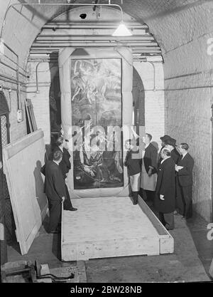 The famous painting 'Adoration of the Shepherds' by El Greco as arrived at the Royal Academy in London after being transported under armed guards from Romania. The picture has been lent by King Carol of Romania for the Exhibition of European Art of the 17th century opening at Burlington House early in June. Photo shows, the picture 'Adoration of the Shepherds' being unpacked and past by a customs official at Burlington House. Right (nearest camera) is Mr Blackley, who had charge of it journeys journey. 22 December 1937 Stock Photo