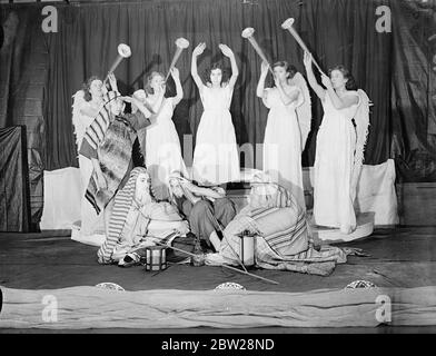 London school children produce their own nativity play. Children of the Hugh Middleton school, Clerkenwell, London, are producing their own Nativity Play for Christmas. The children are helping to make their own dresses and scenery. Photo shows, children rehearsing one of the scenes from the play, 'The Angels Come upon the Shepherds'. 22 December 1937 Stock Photo