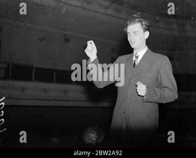 Youngest conductor, son of violinist. Makes debut at Queen's Hall. One of the youngest men ever to conduct the famous orchestra, 23-year-old Rafael Kubelik, son of yJan Kubelik, the world-famous violinist, is making his debut in England with the Prague Philharmonic Orchestra at the Queens Hall, London, tonight (Wednesday). The orchestra is to tour Britain. Photo shows, Rafael Kubelik conducting the Prague Philharmonic Orchestra at the Queens Hall this evening (Wednesday). 13 October 1937 Stock Photo