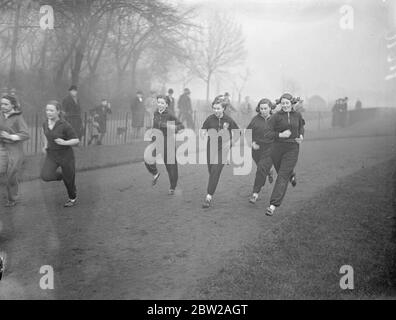 The girls had to have the Sunday 'work out' but drew the line at shorts!. Despite cold and mist, hardy girl members of the Victoria Park Ladies Athletic Club had the Sunday practice in Victoria Park. Photo shows, girl athletes of Victoria Park, LAC, running around the track in long trousers, instead of shorts at Victoria Park. 28 November 1937 Stock Photo