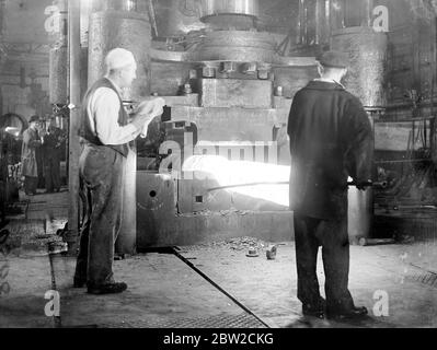 Where Britain forges victory. This pictures were taken in a Royal Ordinance factory of the Ministry of Supply where, thousands of workers are producing arms and ammunition which will help to ensure the victory of Britain and her Allies. Photo shows: forging a jacket for a big gun. Pressure of 1500 tons is applied 13 November 1939 Stock Photo