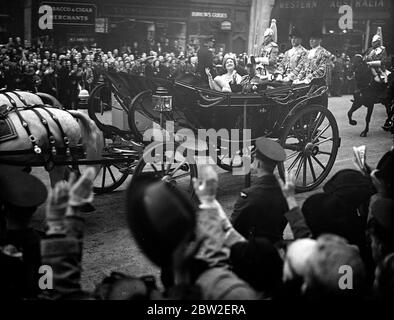 The Royal tour of Canada and the USA by King George VI and Queen Elizabeth , 1939 . King and Queen celebrated the first day of their return by attending an official luncheon at the Guildhall , London , Britain . The King and Queen driving through the Strand . Stock Photo