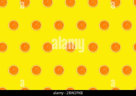 Cutted orange slices on yellow background seamless pattern. Stock Photo