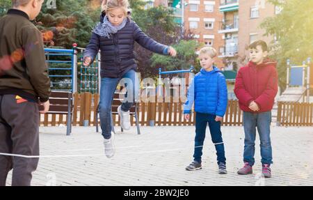 Playground Rjump Rope Children jump through an elastic rope in a children playground Stock ...