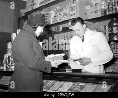 War 1939-1940. Rationing - cutting out the coupons for sugar at the grocer's. 8 January 1940 Stock Photo