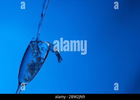 Clear, drinking water falls into a clear glass, healthy, wholesome, fresh water with no odor or taste. Splash of water drops splashing onto the surfac Stock Photo