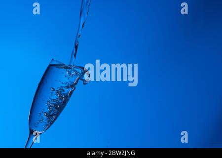 Clear, drinking water falls into a clear glass, healthy, wholesome, fresh water with no odor or taste. Splash of water drops splashing onto the surfac Stock Photo