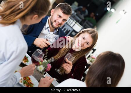 Gentleman with elegant women are having dinner in luxury restaurante indoor. Stock Photo