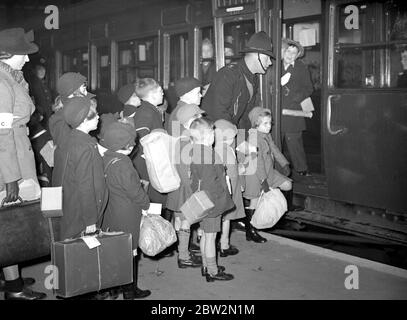 War Crisis, 1939. Air Raid precautions Second World War began, and evacuees, like these in this picture, began to pour out of London for safety of the countryside. Carrying gas-mask cases,luggage labels identifying them, fixed to their clothing, it was for some of them a Great Adventure, for many of them had never left home, or even London before. Children leaving for Devon. 14 December 1939 Stock Photo