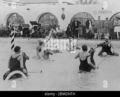 Water polo on rubber horses at Palm spring california . Water polo with rubber horses and woodedn mallets , is the latest sport for women at the seaside resorts in California . the game causes excitement steady balance being required for competitors to remain on their floating horses . A game of water polo in progress at the El Mirador Springs Pool , Palm Springs , California . 24 February 1932 30s, 30's, 1930s, 1930's, thirties, nineteen thirties Stock Photo