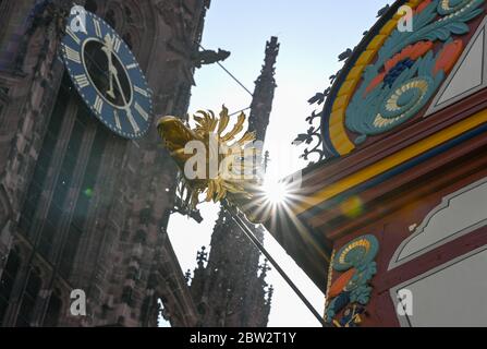 29 May 2020, Hessen, Frankfurt/Main: The sun shines between the cathedral and the 'Goldene Waage', a reconstructed half-timbered house in the new old town. Photo: Arne Dedert/dpa Stock Photo