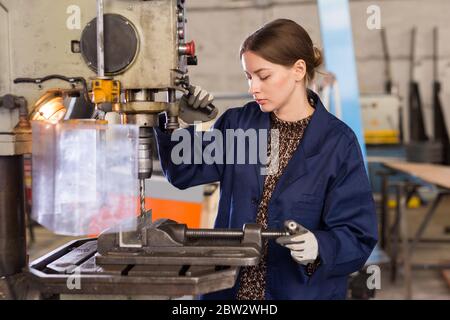 Portrait of confident  woman  mechanic using drilling machine  in workshop Stock Photo