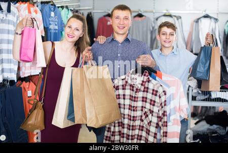 Young spouses with their son admire new purchases in the market Stock Photo