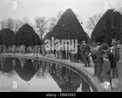 Sunday crowds at Hampton court . The brilliant sunshine of the first Sunday of spring brought out large numbers of visitors to Hampton Court Palace . Crowds at Hampton Court Palace beside the lily pond . 20 March 1932 . Stock Photo