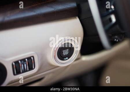 A Start-stop button to start the engine in a luxury car. A button located on the left side of the steering wheel. Stock Photo