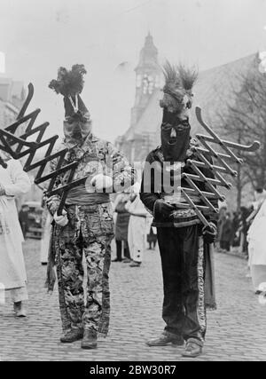 Hooded giants in Ypres carnival procession . Two hooded giants in the great Ypres , Belgium carnival procession , which was watched by thousands of visitors to the town from all over the country . 9 February 1932 Stock Photo