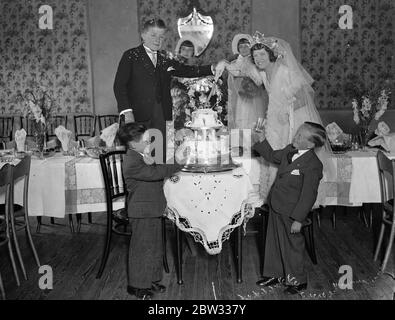 England ' s tiniest bride and groom marry at Mitcham . Miss Dorothy Kathleen Griffiths , who is only 3 feet 10 inches tall , and Mr Vivian Pascoe , who is two inches taller , both belonging to a midget circus troupe were married at St Barnabas Church , Mitcham , Surrey . The wedding was attended by members of the Theatrical Company with whom they are playing . The bride and groom with the bridal party at the wedding . 14 August 1932 Stock Photo