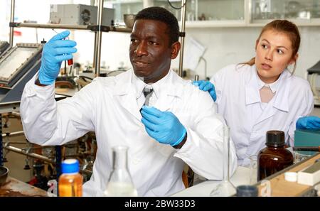 Worried lab technicians checking for result of unhappy experiment in laboratory Stock Photo
