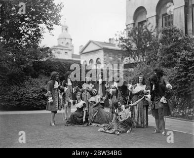 Society rehearse for entertainment in the gardens of No 10 Downing Street . Many society people took part in a dress rehearsal of an evening entertainment held in the grounds of No 10 Downing street in aid of the Distressed areas in the north . 1 group of characters in the reign of Queen Anne , photographed in the gardens of No 10 . 13 July 1932 Stock Photo