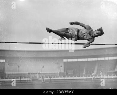 Oxford athletes train for meeting with Cambridge at White City . The Oxford team who are to meet Cambridge in the inter varsity sports at the White City on Saturday , trained at the White City , London . C S Stanwood of Wellesley Hills , Mass , USA , in fine action in the high jump , during practice . 13 March 1933 Stock Photo