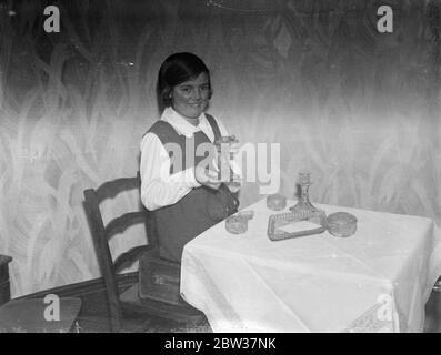 Queen 's Christmas gift to  adopted  orphan . Five years ago , Ivy , a little inmate at the Princess Mary Home for Little Girls at Addlestone , Surrey , was  adopted  by the Queen . Ever since , at Christmastide , Her Majesty has sent a gift to her protegee . Photo shows ; Ivy , aged 12 , with the Queen 's gift , a dressing table set . 20 December 1933 Stock Photo