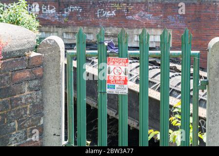 Warning sign beside a pipe bridge on the Birmingham and Fazeley Canal in Nechells, Birmingham Stock Photo