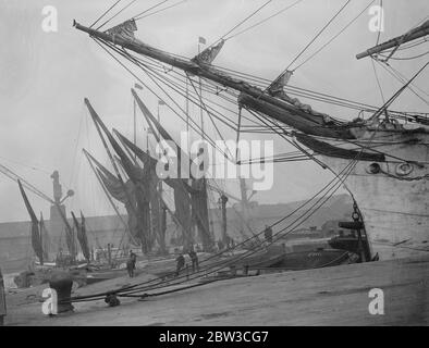 Fog brings shipping to standstill in the Thames estuary . Thames sailing barges moored up , causing congestion in Surrey . 22 November 1934 Stock Photo