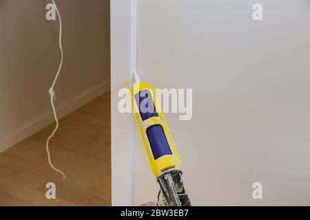 Carpenter using for when you need to cover small holes and tiny cracks prior to painting, painter s caulk, an acrylic latex compound wall repairing in house door molding trim Stock Photo