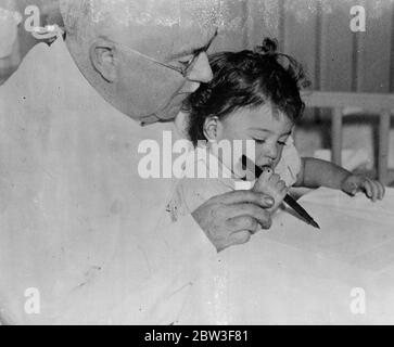 Quins , first writing lesson . Grasping her fountain pen with determined hand Emilie , under the gentle guidance of Dr Dafoe , had her first writing lesson at the Dionne Quintuplets ' nursery in Callander , Ontario. But as she seemed rather more interested in the working of the doctor ' s fountain pen than in the writing , the lesson wasn ' t quite a success . Photo shows , Emilie takes her first writing lesson under the guidance of Dr Dafoe . 15 March 1936 Stock Photo