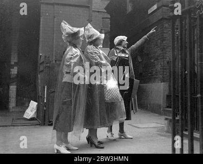 Invisible  Protection Against English Summer - American Girls Introduce New Fashion To London A party of American girls from Chicago have introduced a new invisible fashion to London during a European tour . It is waterproof cape completely transparent and weighing only two ounces . The cape is 10 per cent . rubber and when not in use folds into an envelope six inch by four . It costs about four shillings and provides covering from head to foot . Photo shows : The girls wearing their transparent capes as they inspected Dr . Johnson ' s house in the City . 13 Jul 1936 Stock Photo