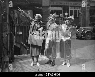 Invisible  Protection Against English Summer - American Girls Introduce New Fashion To London A party of American girls from Chicago have introduced a new invisible fashion to London during a European tour . It is waterproof cape completely transparent and weighing only two ounces . The cape is 10 per cent . rubber and when not in use folds into an envelope six inch by four . It costs about four shillings and provides covering from head to foot . Photo shows : The girls wearing their transparent capes as they inspected Dr . Johnson ' s house in the City . 13 Jul 1936 Stock Photo