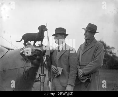 Dog takes part in air race . Twenty five aeroplanes , three American , one Czechoslovakian and 21 British were entered in the London , to Isle of Man air racewhich started from Hanworth Aerodrome . Leading RAF and civil pilots are competing . Photo shows , Flyinng officer Clouston ( left ) and Flight lieutenant Guyler with Clouston ' s dog Chota , which is flying with them in their Aeronca- Jap J-99 . The dog has done over 100 hours flying . 30 May 1936 Stock Photo