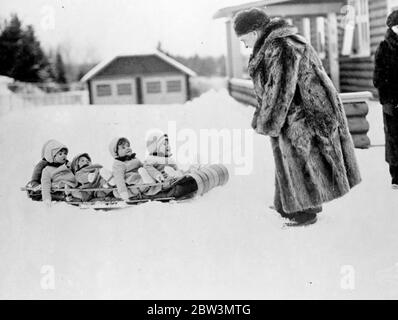 The Dionne Quintuplets have a thrilling sledge run . The Dionne Quintuplets had their first taste of the thrills of winter sport in the garden of their private hospital at Callender , Ontario , after several heavy snowfalls . Snugly wrapped up in their warm woollies the Quins were taken for a sledge ride by Dr A P Dafoe . Photo shows , Annette Dionne , one of the famous Quintuplets , wrestles with the problem of making snowballs with her hands pinned in her sleeves at Callender , Ontario . 19 April 1936 Stock Photo