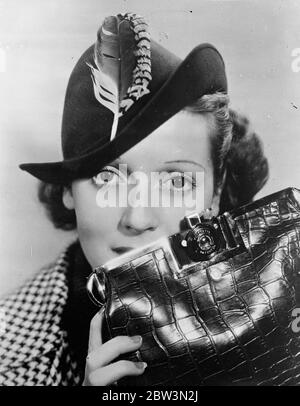 Handbag that sees all . Flap conceals a camera . The keen woman amateur photographer will no longer have the inconvenience of carrying a camera . American inventors have come to her aid and have produced a combined camera and handbag . A miniture camera is let into the side of the bag near the clasp and is concealed beneath the flap . Photo shows , Rosalind Keith , the Hollywood film actress , demonstrates the new handbag camera . 17 May 1936 Stock Photo