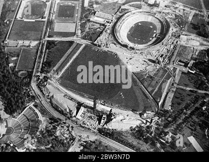 Germany ' s Olympic stadium from the air . An aerial view of the the great Olympic Games centre near Berlin as it nears completion . In the upper part of of the picture can be seen the chief stadium with the swimming pool on left . In foreground is the polo field with the Olympic clock tower at the entrance . 19 March 1936 Stock Photo