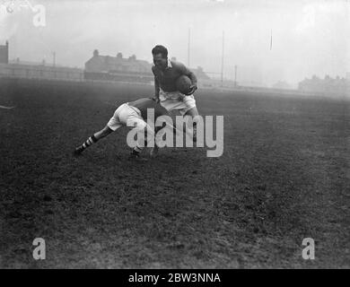 George Nepia , famous all black , has trial before debut in London league rugby . George Nepia , considered the greatest rugby full back since the war , had a trial at Mitchs Stadium , having arrived in London to play rugby league football for the Streatham and Mitcham Club . Nepia casued a sensation in 1924 when he was a star member of that famous all black side . Nepia has hopes of playing tomorow ( Saturday ) against Wigan , but the decidion depends on the result of his tryout today . Photo shows , George Nepia handing off an opponenet during the trial at Mitcham . 13 December 1935 Stock Photo