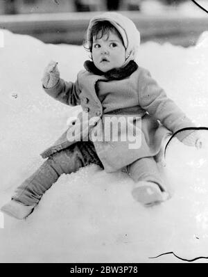 The Dionne Quintuplets have a thrilling sledge run . The Dionne Quintuplets had their first taste of the thrills of winter sport in the garden of their private hospital at Callender , Ontario , after several heavy snowfalls . Snugly wrapped up in their warm woollies the Quins were taken for a sledge ride by Dr A P Dafoe . Photo shows , Annette Dionne , one of the famous Quintuplets , wrestles with the problem of making snowballs with her hands pinned in her sleeves at Callender , Ontario . 19 April 1936 Stock Photo