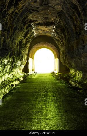 Inside a former railroad tunnel looking towards the light at the end of the tunnel. Stock Photo