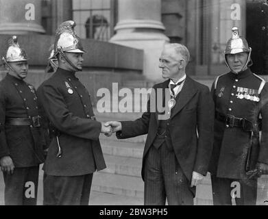 Hero of Soho fire receives ' fireman ' s VC ' from Lord Snell at County Hall . Attended by an escort of five firemen and a ststaion officer in full dress , Firemen J W Root of the Soho Station received the ' Firemen ' s VC ' from Lord Snell , Chairman of the LCC at a meeting of the Council in County Hall . He showed conspicuous bravery at a fire at Peter Street , Soho , on February 29 , in hich five people lost their lives . He received injuries . lord Snell also handed firemen Root a cheque for Â£ 10 . Photo shows , Firemen J W Root being congratulated by Lord Snell after he had received the Stock Photo