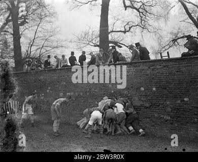 Collegues and oppidans play Eton game in mud . The annual Wall Game , the traditional struggle between Collegers and Oppdiana took place at Eton College as part of the St Andrew ' s Day celebrations . Each side worked hard to score the first goal for 26 years , but rain made play extremely difficult . Photo shows , the wall game in progress . 30 November 1935 Stock Photo