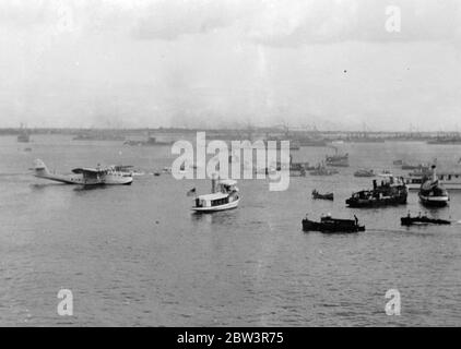 China Clipper  arrives at Manila after first trans Pacific air mail flight . The  China Clipper  taxi-ing to the landing barge after her arrival at Manila . In the distance American warships can be seen in gala dress . 19 December 1935 Stock Photo