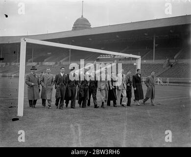 Sheffield United inspect cup final pitch at Wembley . The Sheffield United team which is to meet Arsenal in the FA Cup Final tomorrow ( Saturday ) inspected the pitch at Wembley Stadium . Photo shows , the team walking onto the pitch through the goalposts . 24 April 1936 Stock Photo