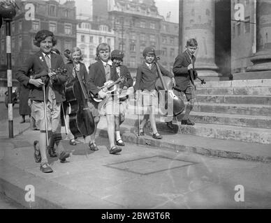 London ' s Musical Children Play At The Queen ' s Hall . Hundreds of young musicians are taking part in the School Orchestra and Junior Band Festival at Queen ' s Hall , London . Photo shows : Childrens arriving with their instruments . 16 May 1936 Stock Photo