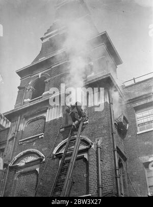 London Fireman Give Rescue Display . A display of rescue work , fire fighting and drill was given by members of the London Fire Brigade at the Brigade ' s Headquarters , Southwark . Photo shows : Firemen rescuing a man from a burning building at the display . 26 August 1936 Original caption from negative Stock Photo