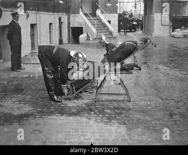 London Fireman Give Rescue Display . A display of rescue work , fire fighting and drill was given by members of the London Fire Brigade at the Brigade ' s Headquarters , Southwark . Photo shows : firemen using an artificial respiration apparatus on a person overcome by smoke . 26 Aug 1936 Original caption from negative Stock Photo
